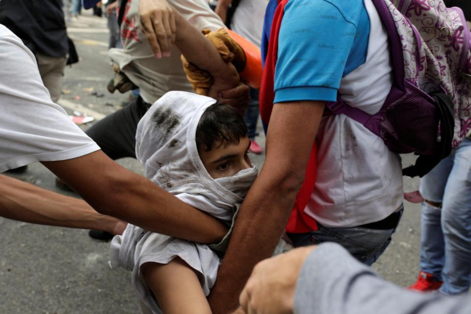  The young-looking protester stares in shock as they are taken from danger