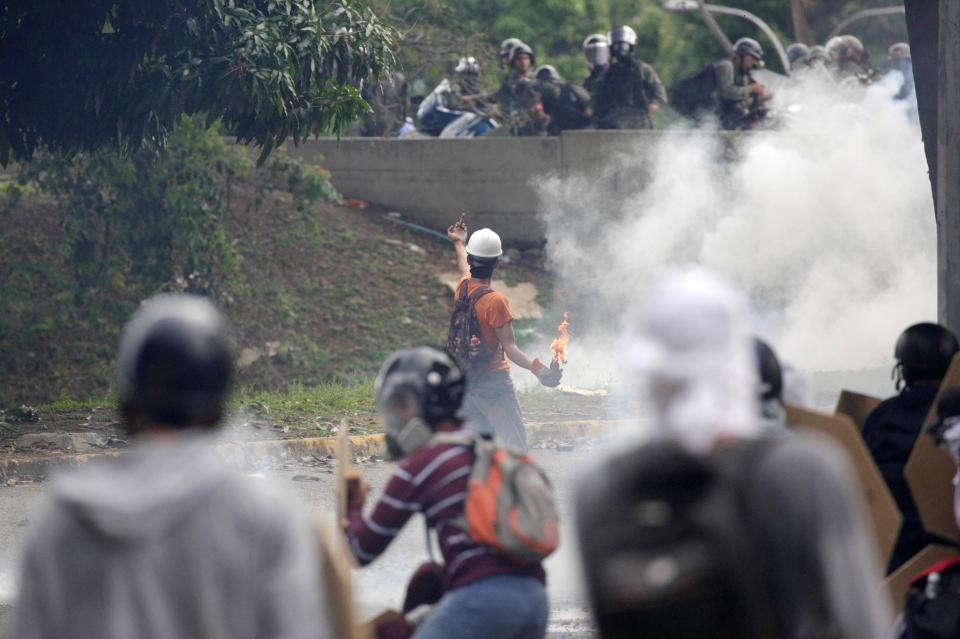  A swearing protester moments before launching a petrol bomb towards riot police