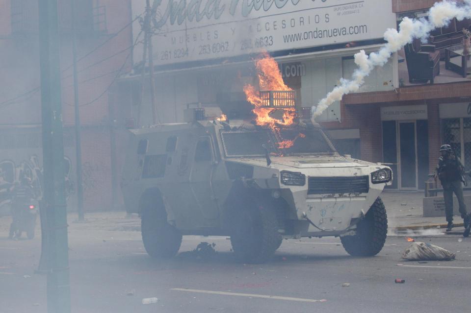  A police riot van is dramatically struck with a petrol bomb and goes up in flames