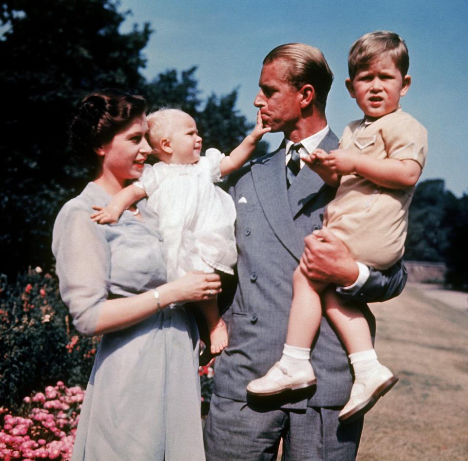  Tender moment . . . baby Anne seems to be trying to silence doting father Philip in the first colour photo of the Princess, taken in 1951, in the arms of her mother the Queen. Her brother Prince Charles in more interested in the camera