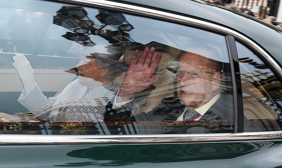  The Duke and Queen Elizabeth wave as they pass crowds outside Buckingham Palace