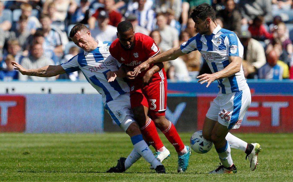 Junior Hoilett is tackled by Huddersfield's Jonathan Hogg 