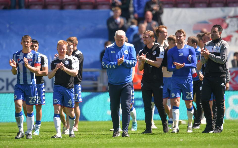  Wigan players clap the fans who made their way to support the side