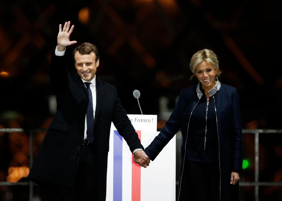  French President-elect Emmanuel Macron holds hands with his wife Brigitte during a victory celebration outside the Louvre museum