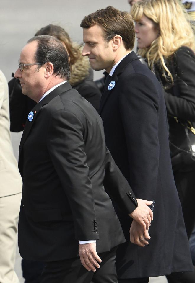  Macron smirks as he walks hand-in-hand with outgoing Socialist Francois Hollande