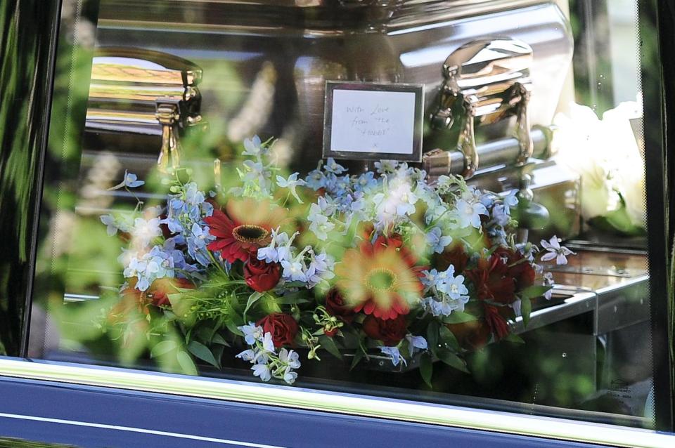  A floral arrangement, accompanied with a message from a loved one, was placed next to the coffin as it made its way towards the service