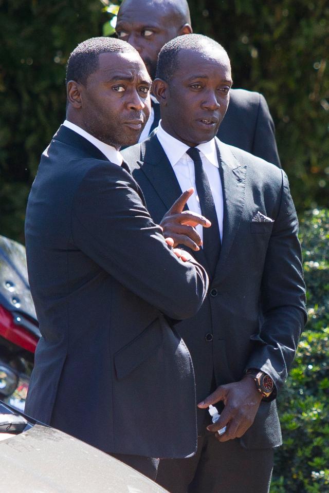  Andy Cole greets a solemn-looking Dwight Yorke, his old Manchester United and Blackburn team mate, outside the church