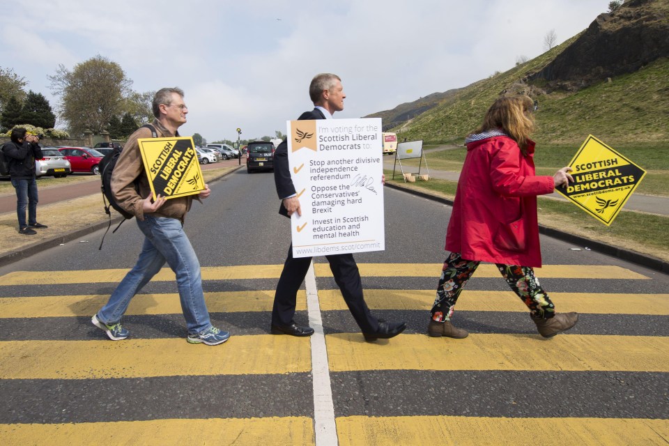 Activists carried the posters across the road in a mocking of the famous Beatles Abbey Road shots