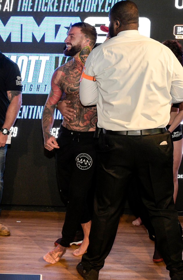 Aaron Chalmers is held back by security after being pushed by Greg Jenkins