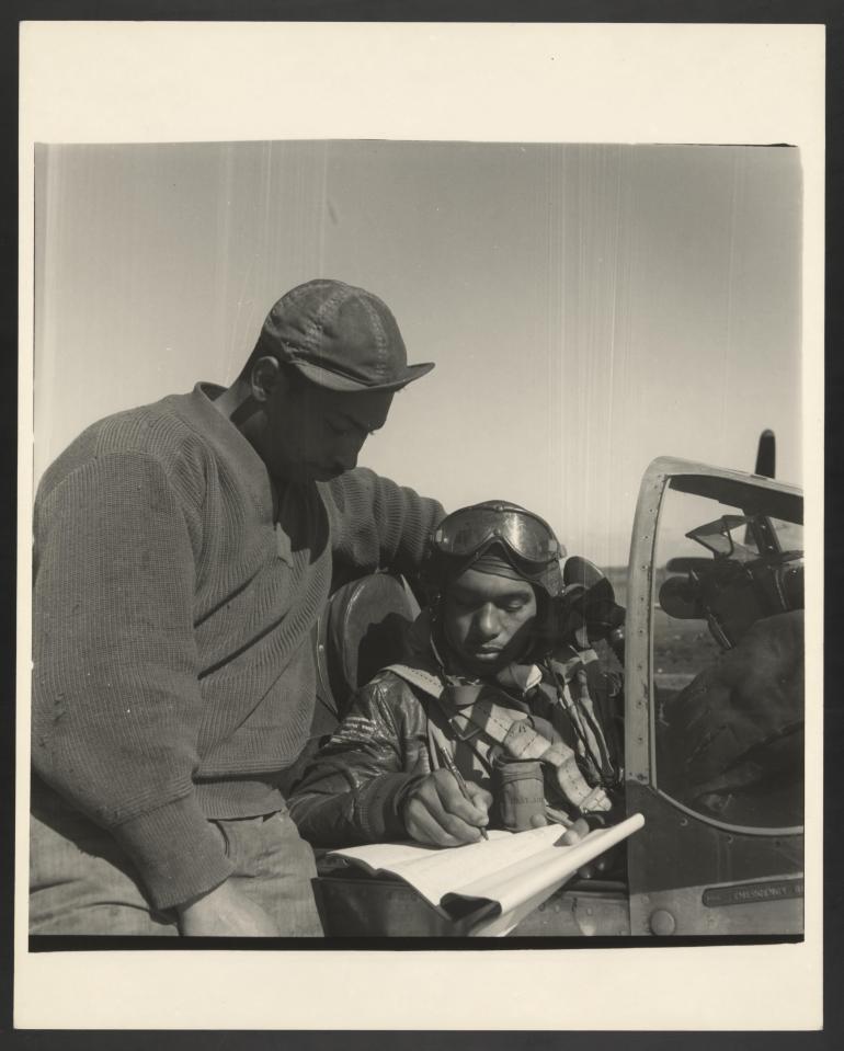  A Tuskagee airman signs a form ahead of flying out on a mission