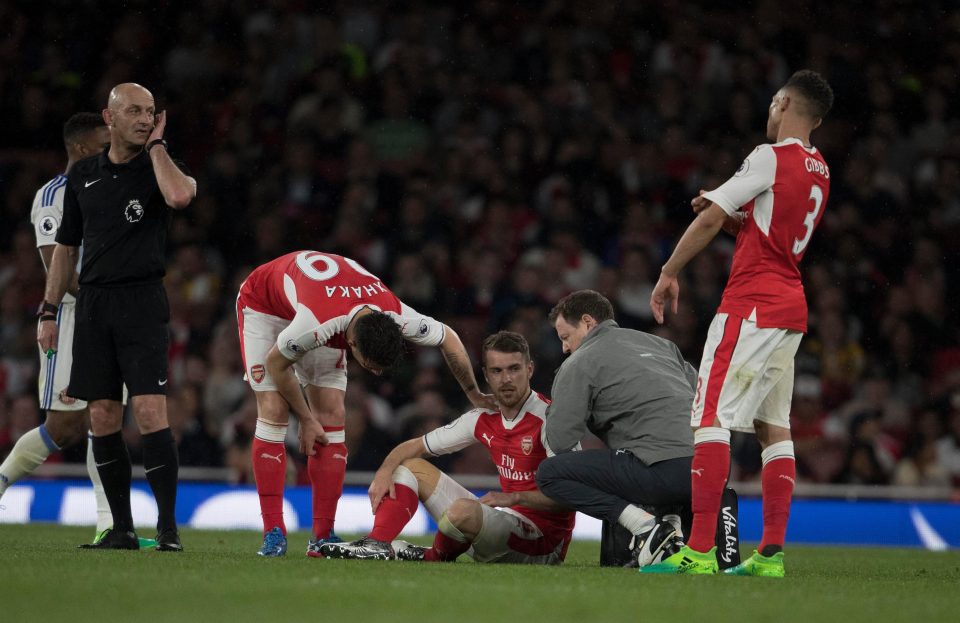  Aaron Ramsey is treated by a member of the medical team after pulling up