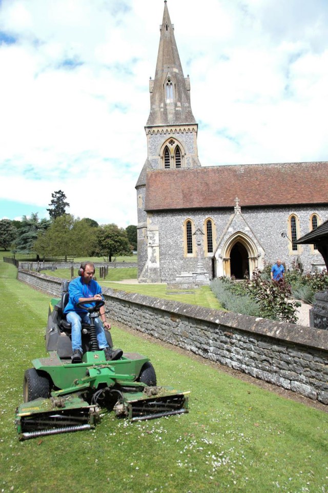 A gardener gives the church grounds a last minute trim