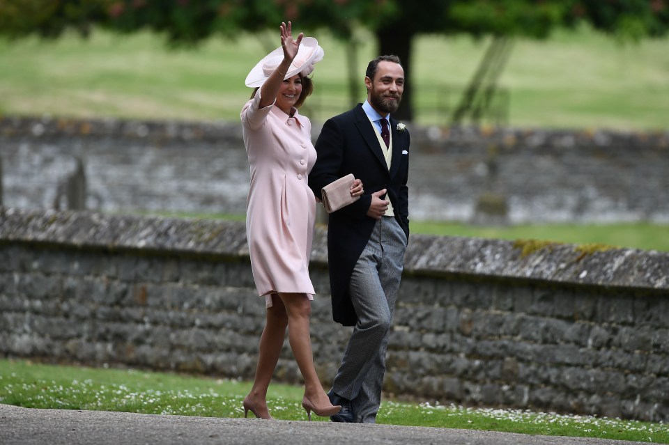 Mother of the bride Carole Middleton waves as she walks towards the church with her son James