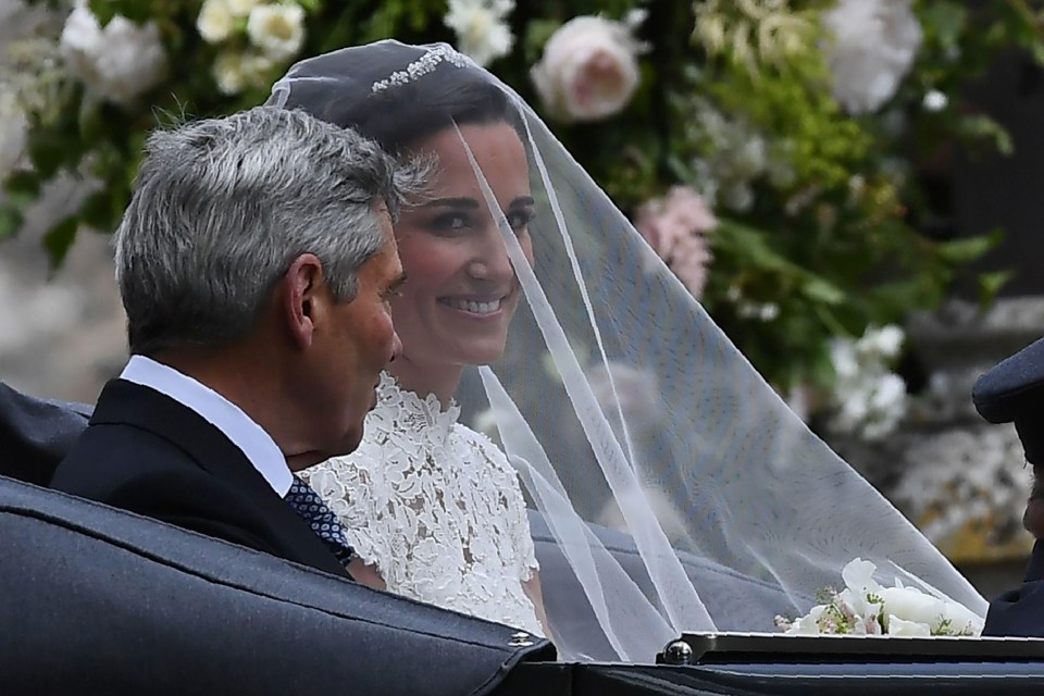 Beaming Pippa covered by a veil sits with her father Michael in open-top car