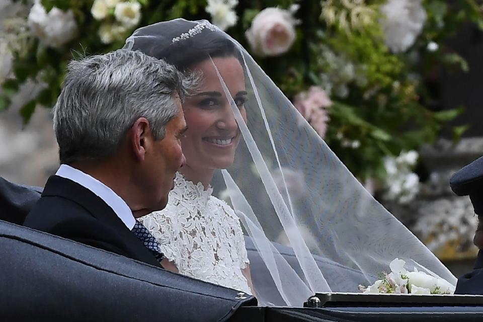  Beaming Pippa covered by a veil sits with her father Michael