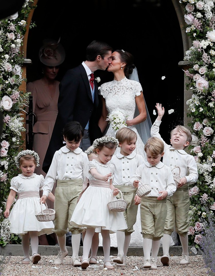 Newly married James Matthews and Pippa Middleton kiss as they stand outside the church behind adorable flower girls and page boys