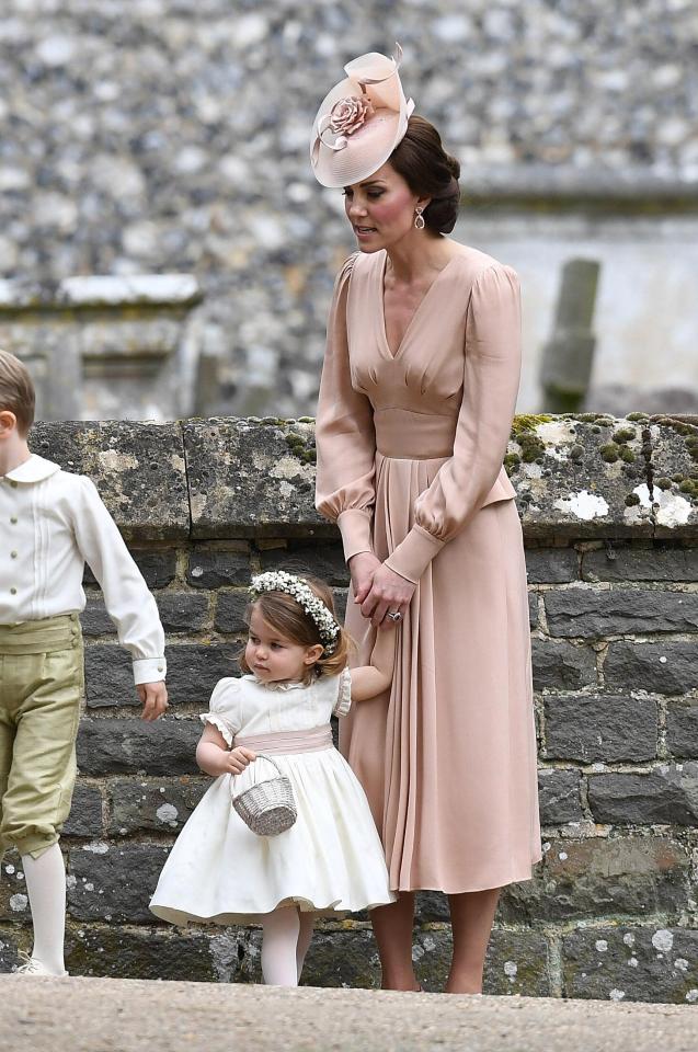  Kate stands holding hands with daughter Charlotte as they stand close to Pippa posing for pictures outside church