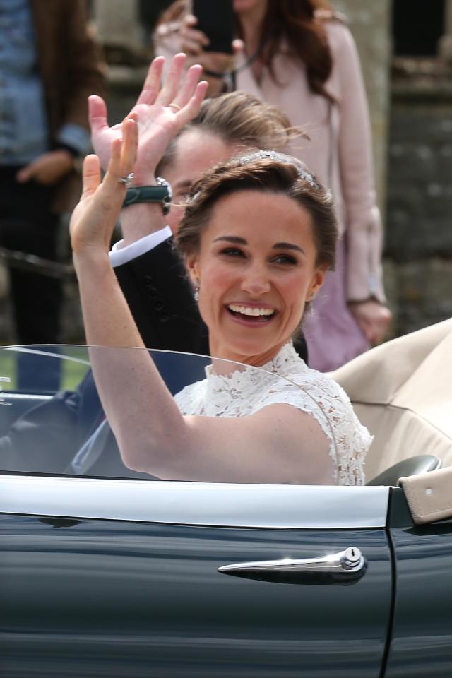  Pippa beams as she waves from the open top car on her way to the wedding reception