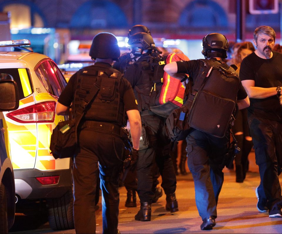  Emergency workers rush towards the arena past people being evacuated