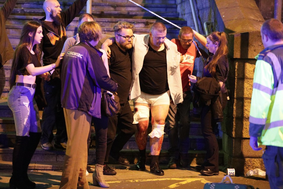 An injured man is led from the arena in Manchester after tonight's chaos