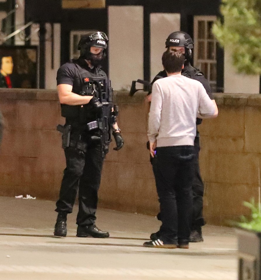 An armed officer guards the scene after the explosion in Manchester overnight