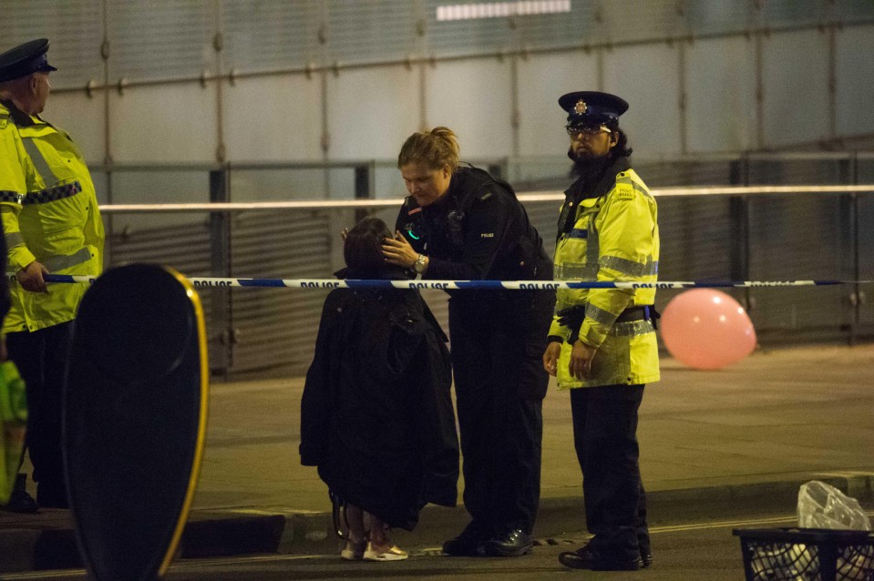 A female police officer comforts a young fan after the atrocity