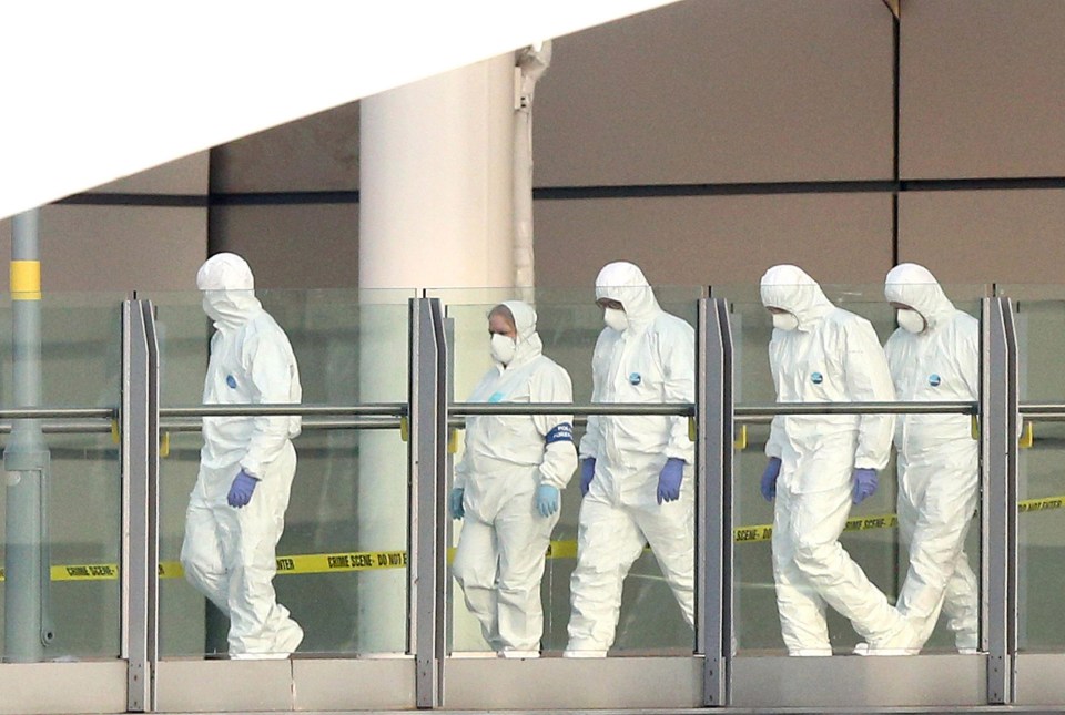 Police forensic officers leave the Manchester Arena as they investigate the scene of an explosion