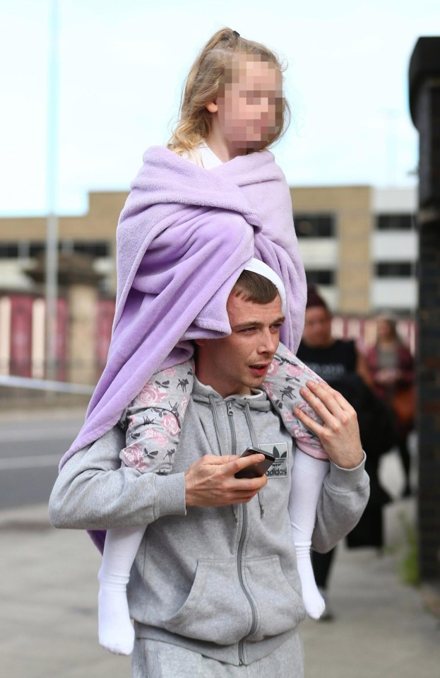 A man carries a young girl on his shoulders near the scene of the attack