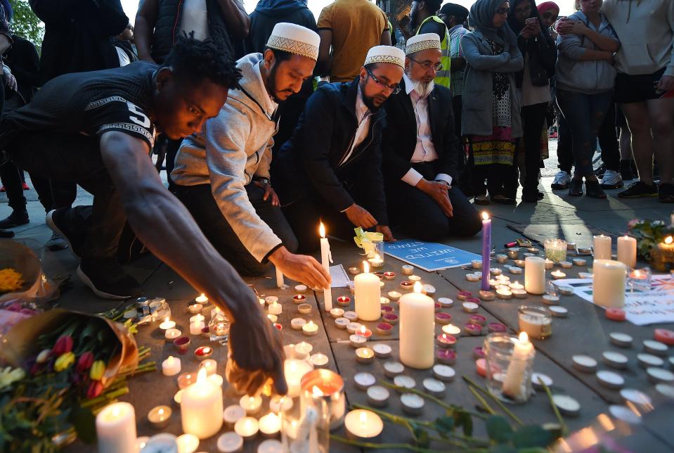  Men light candles at the vigil in Manchester for the victims of the attack