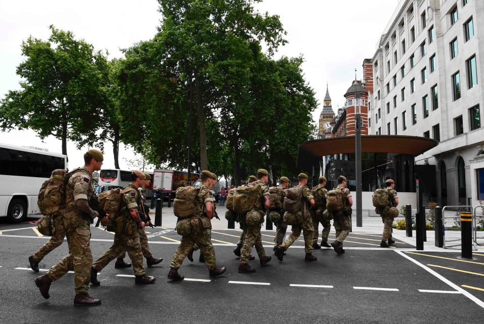  Soldiers arrive by bus and head toward a building near New Scotland Yard police headquarters