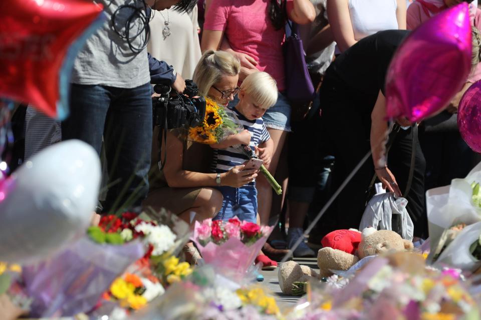  A young boy clutches a bouquet for the victims of the terror attack