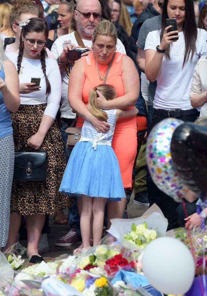  A young girl gets a supportive hug as she attends vigil at St Ann's Square in Manchester this morning