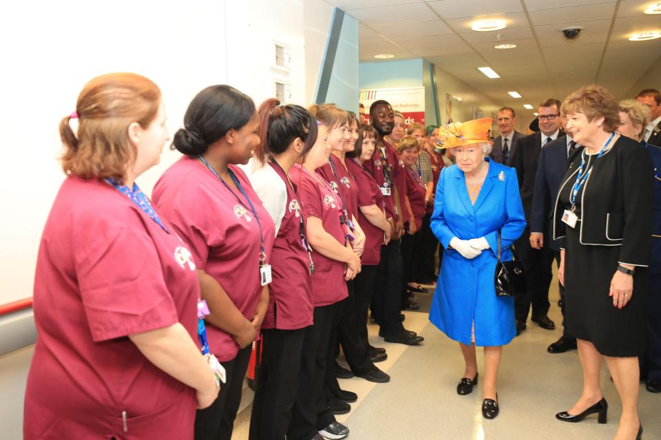  Escorted by hospital Chairwoman Kathy Cowell, right, the Queen is introduced to the team of nurses