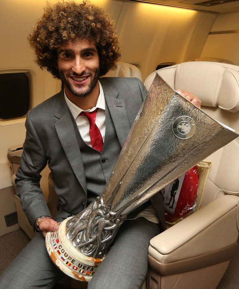  Marouane Fellaini poses with the trophy on the flight from Stockholm