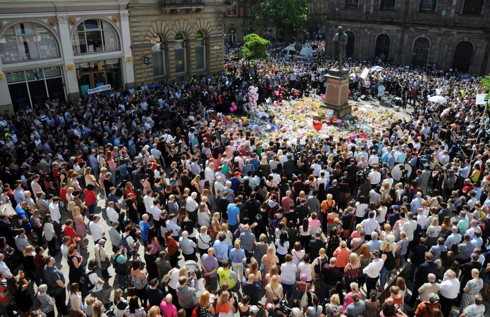  People attend a one minute silence to the victims of Monday's explosion at St Ann's Square in Manchester