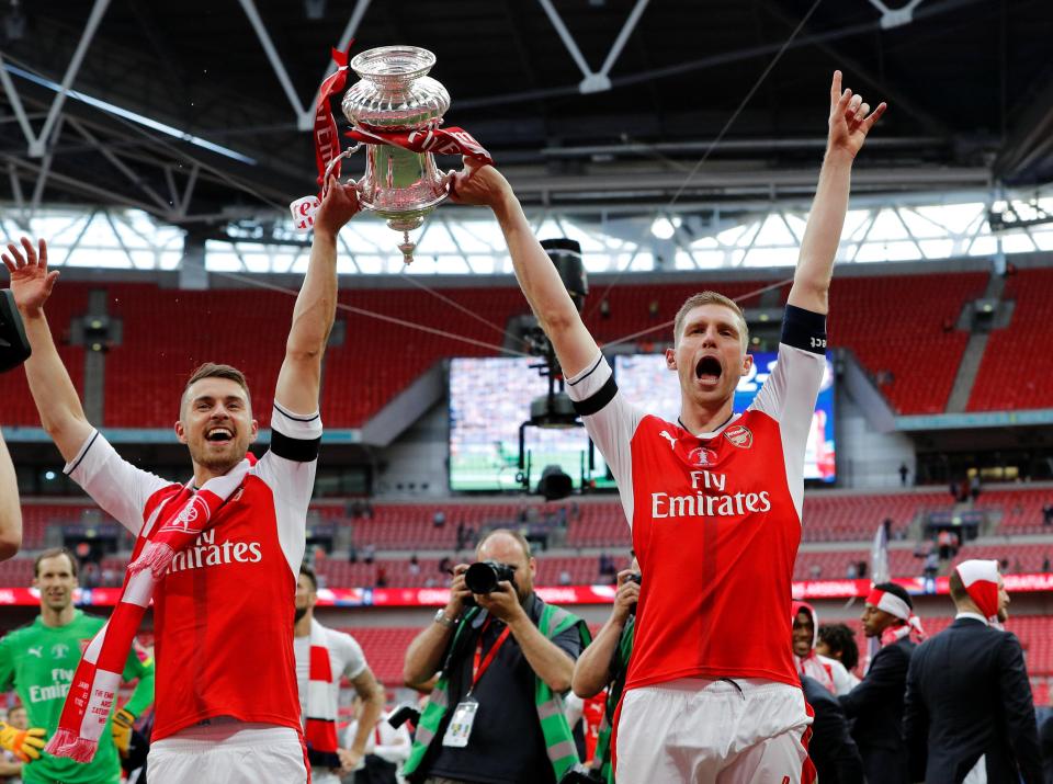  Skipper Mertesacker celebrates with Aaron Ramsey, who scored the winner