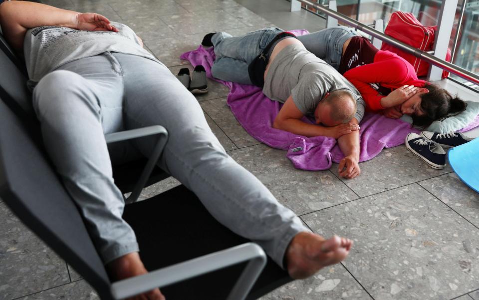  Sleeping bodies lie strewn across the airport lobby