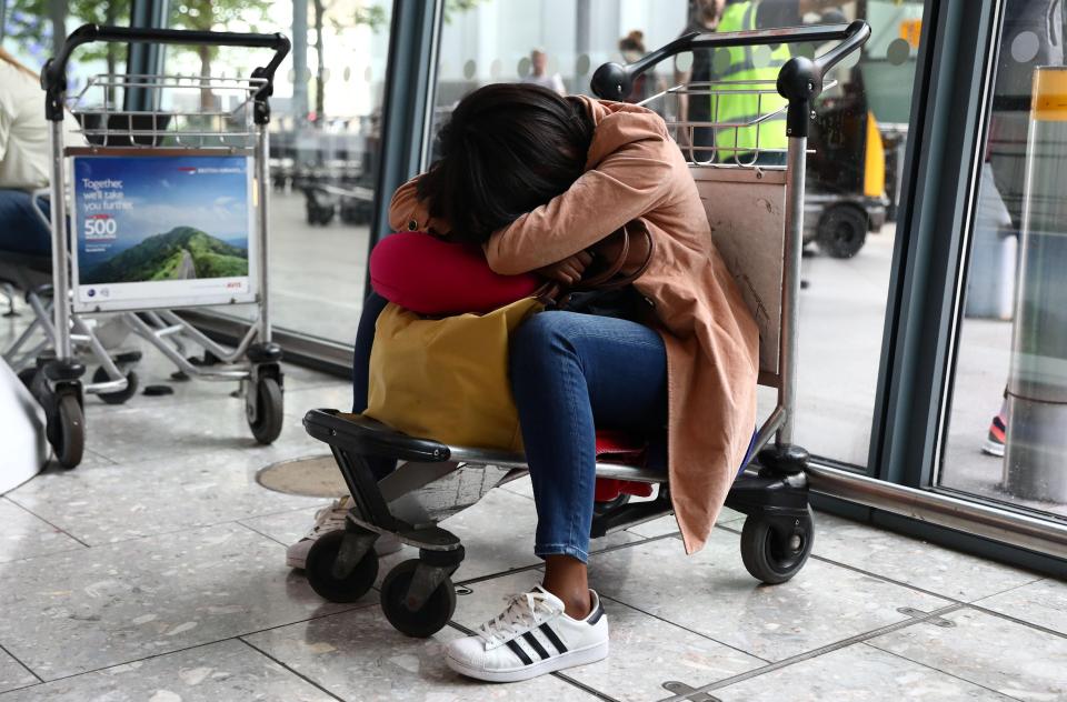  A traveller naps while waiting for the backlog of flights to be corrected