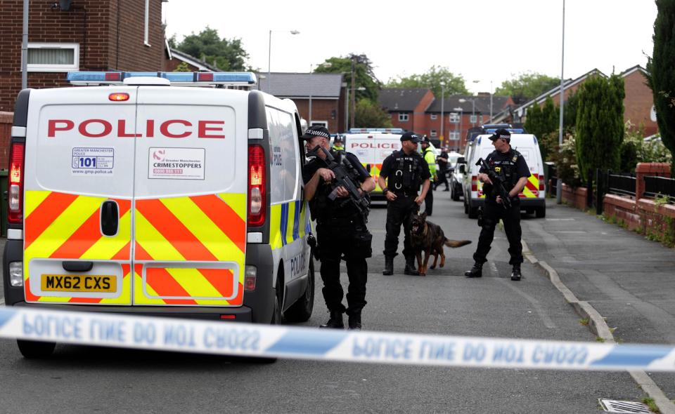  Cops cordon off a street in Moss Side, Manchester as the raid unfolds