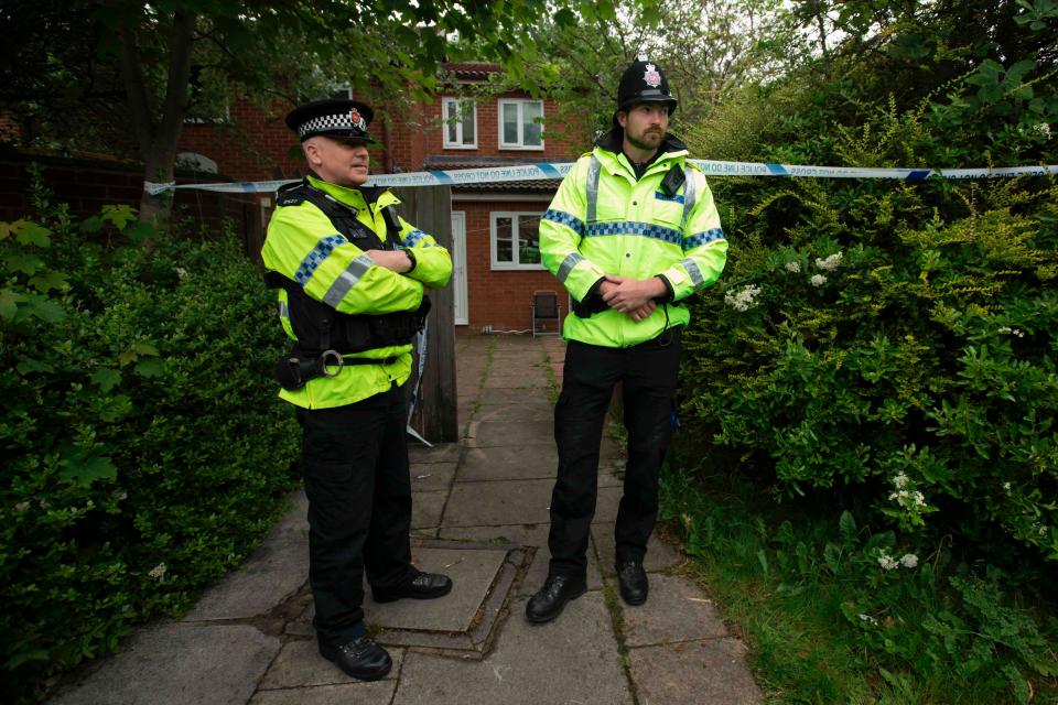  Two cops stand guard outside a house in Whalley Range today