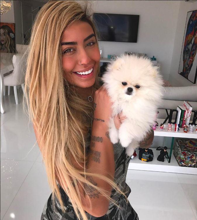  Rafaella holds a fluffy puppy as she smiles for the camera