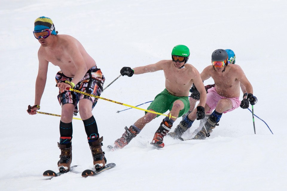 A group of cross-country skiers head off barechested