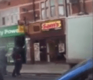  Armed police pictured here aiming weapons up towards flats above some shops in East Ham