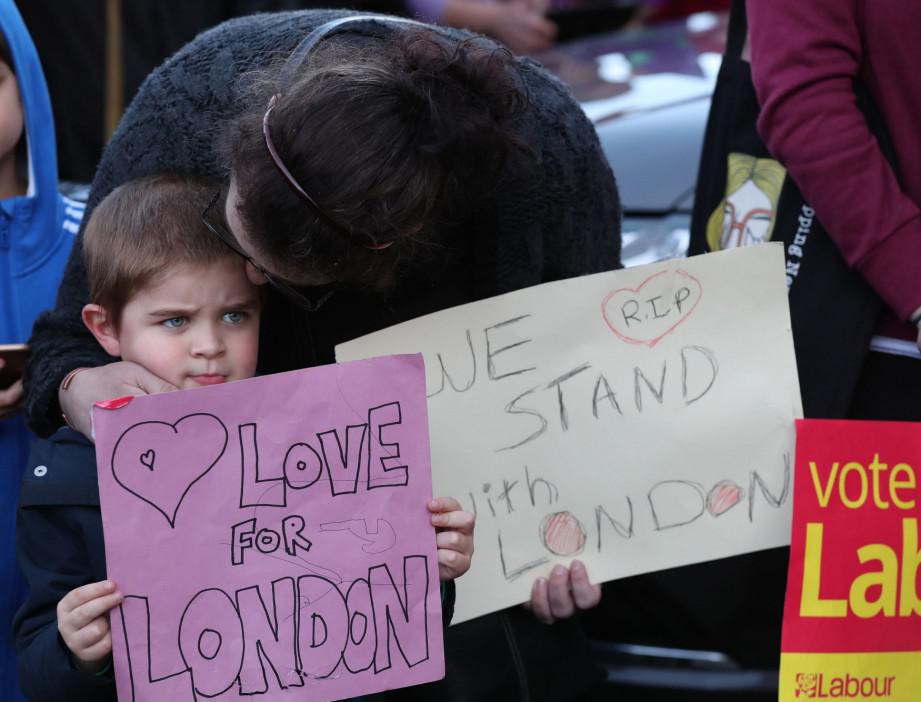 Young supporters hold signs of condolence for the victims of the London attacks, outside the County Hotel where Britain's Labor Party leader Jeremy Corbyn is delivering a campaign speech in Carlisle, Britain