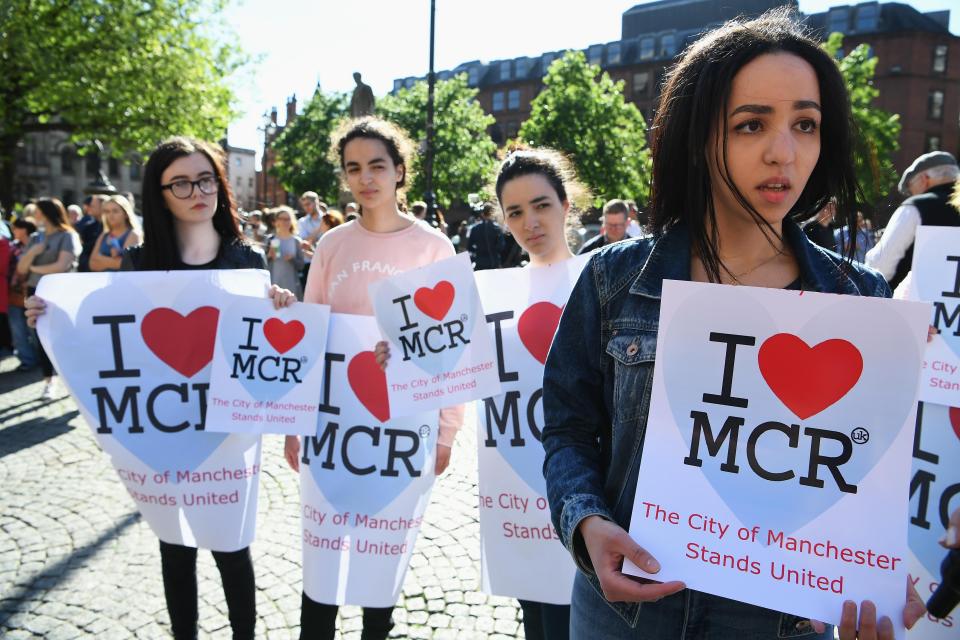  Girls in Manchester hold up signs of solidarity for people affected by the suicide bombing