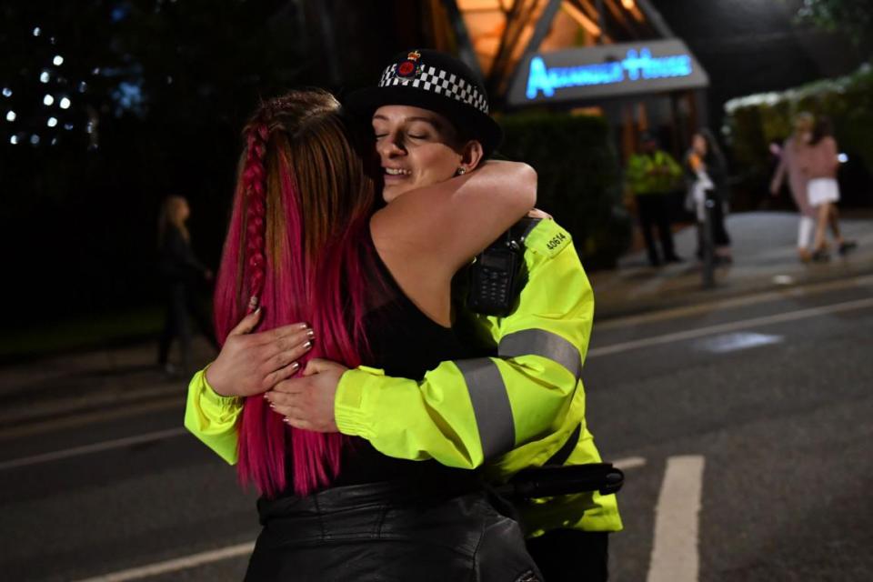  A female police officer hugs another concertgoer