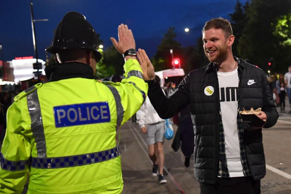 A policeman high-fives a concertgoer leaving the gig