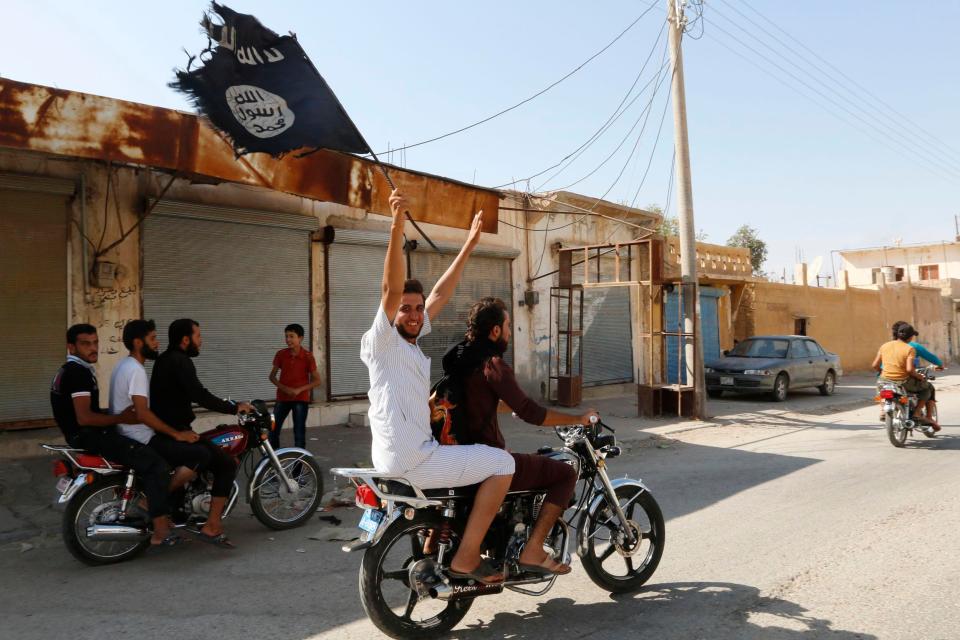  ISIS supporters wave flags in Raqqa, the de-facto capital of the evil caliphate