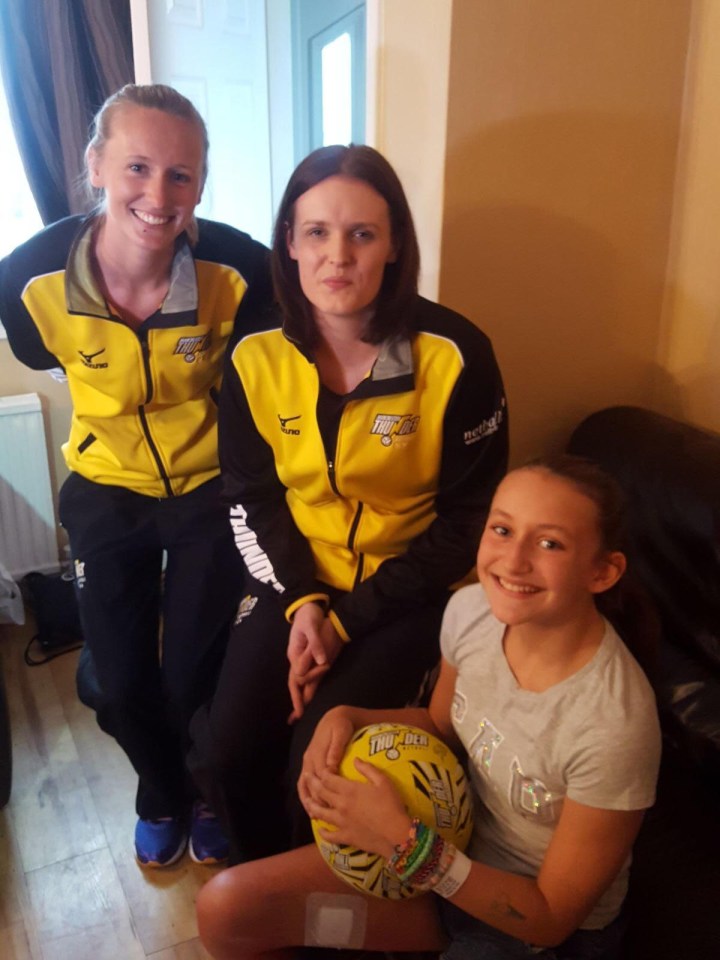 Acacia Seward during s a surprise visit from her netball sporting heroes Manchester Thunder players Emma Dovey, left, and Kerry Almond, right