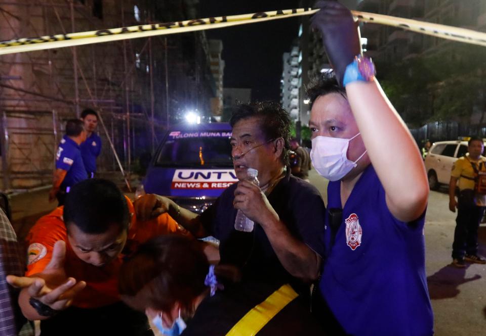  A man receiving treatment from medical responders is evacuated from behind The Resorts World Manila hotel and casino complex